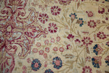 Antique Kermanshah rug's mil fleur design detail: cochineal, sky blue, ivory tones.