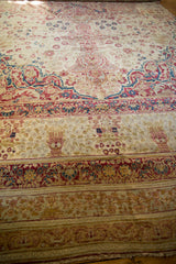 Antique Kermanshah carpet showing lower borders with mil fleur and vase motifs in soft red and blue.