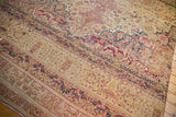 Antique Kermanshah carpet section with mil fleur motifs, cochineal red, sky blue, and aged pile.