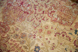 Antique Kermanshah carpet fragment showcasing muted cochineal red, sky blue mil fleur motifs with even wear to knot heads.