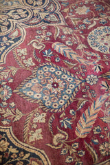 Intricate blue floral medallion detail on the rich red field of Antique Kerman rug.