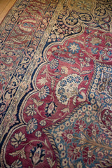 Antique Kerman carpet detail: low pile, plum red field, intricate navy and ivory floral vinery.
