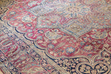 Antique Kerman carpet corner: dense plum red field, mil fleur floral vinery, blue accents.