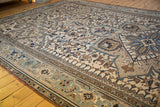 Distressed vintage Heriz carpet detail, geometric vinery, palmettes, ivory, blue, and brown hues.