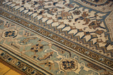 Distressed Persian Heriz rug close-up: powder blue border, ivory field, geometric patterns.