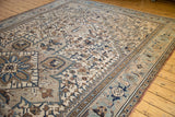 Distressed Heriz rug corner featuring ivory, powder blue geometric vinery and palmettes.