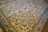 Distressed Heriz carpet's geometric field and border in soft ivory, powder blue, and coffee.