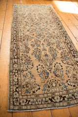 Distressed Sarouk runner showing beige field, blue floral motifs, and mostly even wear.