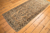 Distressed vintage Sarouk runner featuring faded floral bouquets on an antique ivory field.