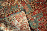 Polychrome side cord selvages and worn geometric pattern of a vintage Heriz rug.