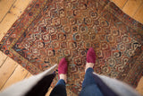 Antique Afshar rug corner, showing geometric lattice, madder red, sky blue, and visible border wear.