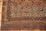 Worn fringed end and outer borders of antique Afshar rug, displaying madder red and blue.