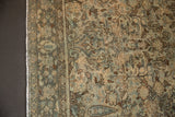 Distressed Hamadan rug showing muted teal and ivory floral pattern with even wear.