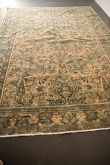 Distressed Hamadan rug corner, antique ivory and dusty teal floral pattern, worn texture, fringe.