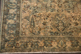 Distressed Hamadan rug corner with pale teal, gold, and ivory floral bouquet motif, showing even wear.