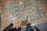 Distressed vintage Hamadan rug with aqua and terra cotta floral vinery and even wear.