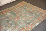 Distressed vintage Hamadan rug's faded aqua and terra cotta floral patterns, with foundation wear.