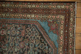 Intricate geometric borders and brilliant blue spandrel on a distressed vintage Persian Malayer rug.