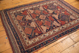 Antique Afshar rug's geometric field motifs and patterned borders in navy, red, and ivory.