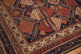 Antique Afshar rug corner: oversized geometric motifs with layered navy, madder red, and ivory borders.