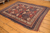 Geometric motifs and secured side of the antique Afshar rug's navy and ivory border.