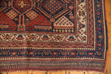 Layered geometric borders of an antique Afshar rug, in navy, madder root, and ivory hues.