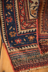 Antique Afshar rug corner shows navy, red, ivory geometric pile, secured edge, fringed kilim.
