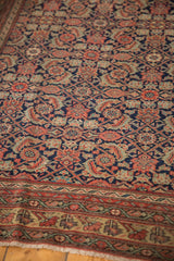 Intricate madder root red and sand gold border of the antique Malayer rug with fringe.