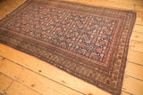 Intricate madder root red, dusty gold border on antique Malayer rug, showing secured side.