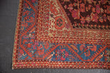 Corner of antique Turkish Kula rug, sapphire blue meandering vine border, aged floral field.