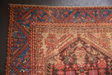Turkish Kula rug corner, sapphire blue vine border, floral field with foundation showing.