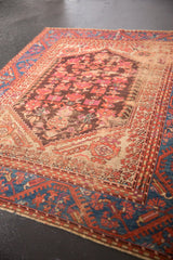 Portion of an Antique Kula rug showing its floral field wear and sapphire blue meandering vine border.