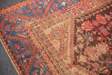 Antique Kula rug border with sapphire blue meandering vines, aubergine floral field, visible foundation.