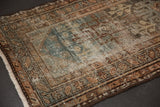 Distressed texture and worn foundation of a vintage Hamadan rug in dusty teal and beige.