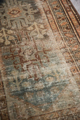 Distressed texture of Hamadan rug in dusty teal, beige, and brown, with exposed foundation.