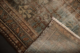 Distressed vintage Hamadan rug pile, showing wear, exposed foundation, and fringe.