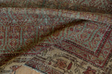 Distressed vintage Hamadan rug texture with madder red and ocean green botanical patterns.