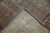 Distressed madder root red and ocean green boteh pattern on a vintage Hamadan rug's hand-knotted foundation.