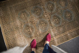 Distressed vintage Jaldar rug corner, with slate grey medallions, beige ground, and worn knots.