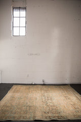 Distressed Northwest Persian rug's surface, featuring faded sand, beige, and blue floral motifs with even wear.