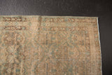 Distressed Northwest Persian rug edge with worn sand and faded powder blue floral motifs.