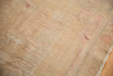 Back of the hand-knotted Oushak rug foundation showing beige weave and hints of raspberry.