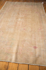 Distressed vintage Oushak rug texture with worn knot heads and intact selvage.