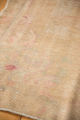 Hand-knotted vintage Oushak rug reverse, revealing beige foundation and subtle pink hues.
