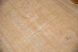 Distressed Oushak rug with even wear, faint foundation showing through, and soft ivory tones.