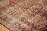 Vintage Meshed rug's textural wear, highlighting antique ivory foundation and cochineal red milfleur motifs.