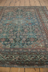 Distressed vintage Malayer rug showcasing faded dusty teal Herati motifs and muted pale rust tones.