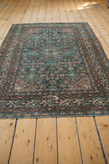 Distressed Malayer rug border with meandering vine, blooming floral design, and even wear.