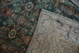 Distressed vintage Malayer rug's low teal pile and contrasting hand-knotted foundation.