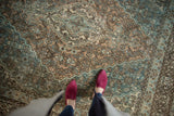 Distressed vintage Persian Bibikabad rug showing ocean blue, ivory, and chocolate Herati motif.